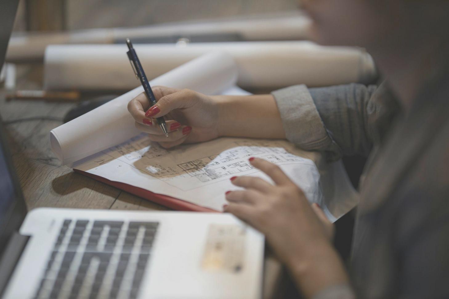 Persona planificando estrategia financiera con documentos y calculadora
